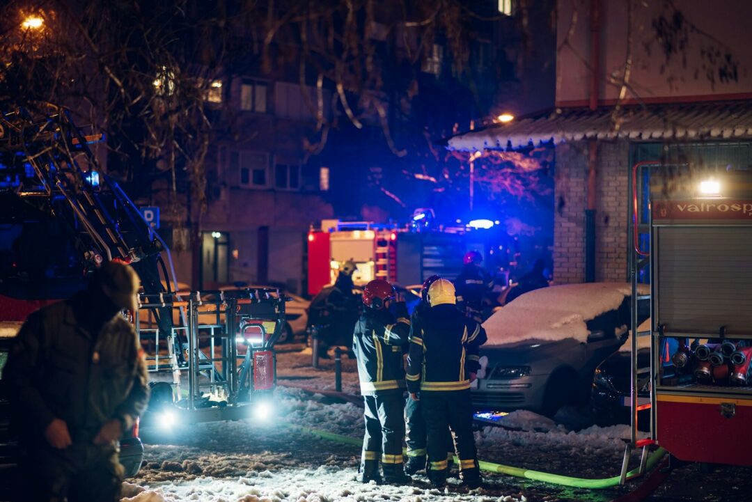 Firemen at work near their truck on the street e1714846742589